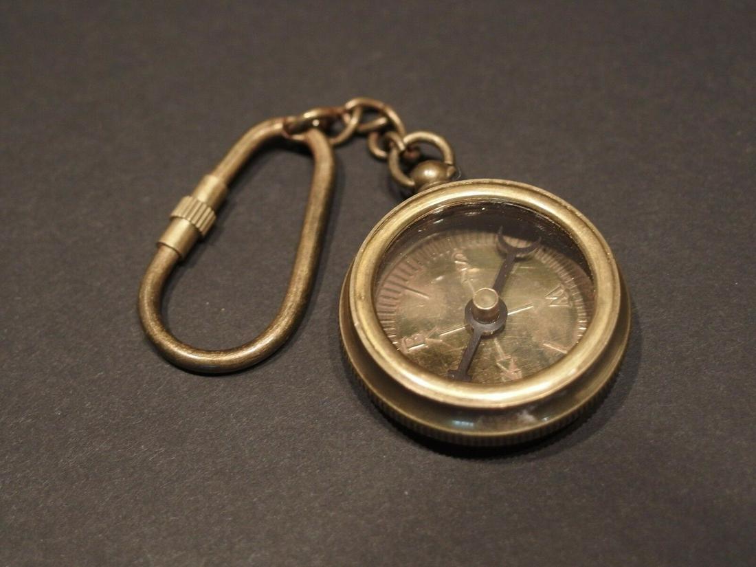 Solid Brass Compass Keychain: 1 3/8" wide Nice reproduction of an antique compass keychain. The compass chain and keychain are all brass distressed to look old. The compass is a standard magnetic compass all the letter and marking