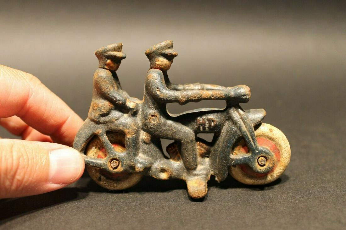 Cast Iron Toy Motorcycle 2 Riders: 4" Long x 2 3/4" Tall Such a neat reproduction cast iron motorcycle! As you can see this heavy cast iron pull toy motorcycle was wonderfully hand painted and distressed to look like an original antiqu
