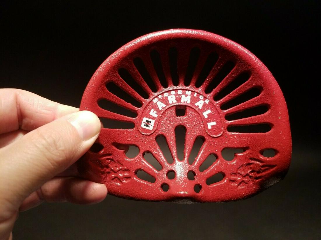 Cast Iron McCormick Farmall Mini Tractor Seat: 4 3/4" x 4" Great reproduction antique folk art cast iron tractor seat. This piece was cast to look just like the larger version likely as a salesman sample. Makes a great paperweight for any collecto