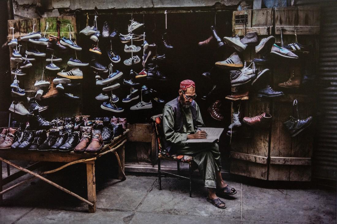 STEVE MCCURRY - Shoe Shop, Kabul, Afghanistan: Artist: Steve McCurry Title: Shoe Shop, Kabul, Afghanistan Medium: Photo Litho, 2012, Italy Dimensions: 14x9.35" Heat Wax Mounted on 14x18" Conservation Board Steve McCurry is an American photographer