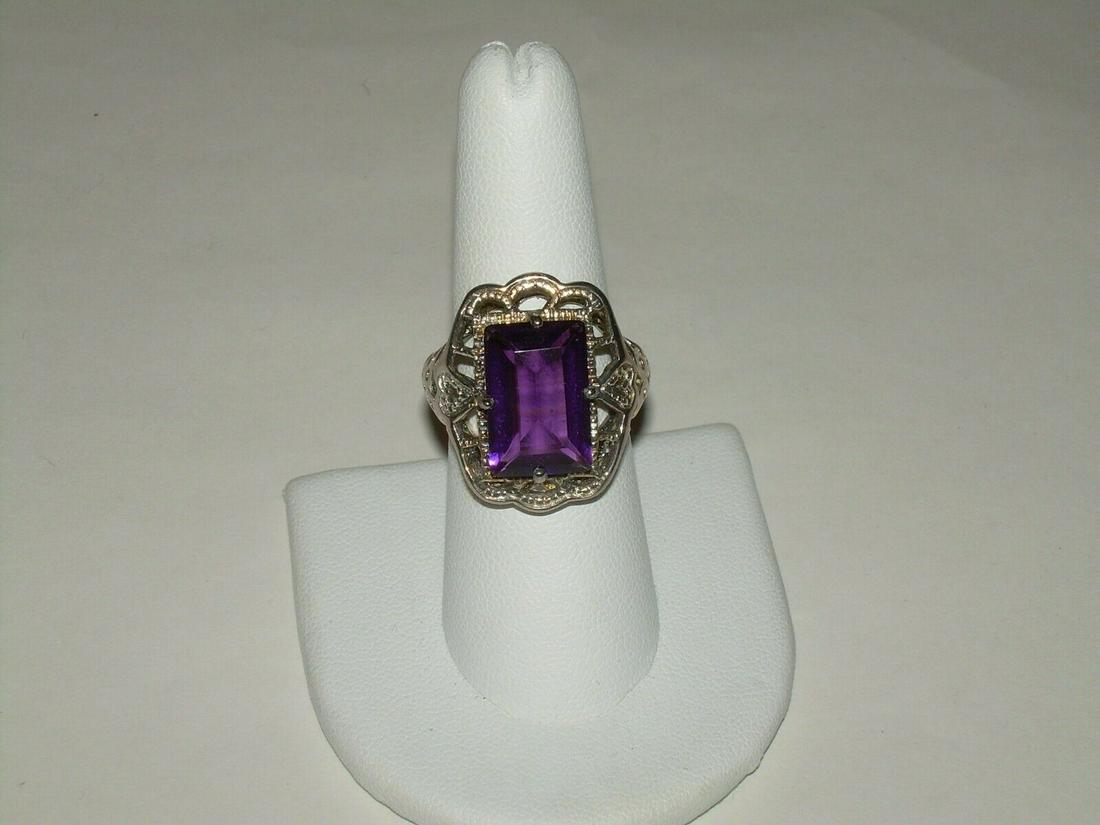 Vintage Sterling Amethyst Cocktail Ring, Emerald Cut: Vintage sterling silver cocktail ring comes with an emerald cut Amethyst stone. The stone is 14.9mm long and 9.9mm wide. The stone is prong set. The ring is an open weave with beaded accents. The fron