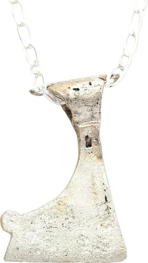 VIKING VOTIVE AXE PENDANT C.900-1000 AD: Form of the iconic Viking battle axe, scaled to 1 ½” tall. Bearded bit decorated with hound’s tooth and stipple bands. One side quite complete, the other weak from wear. Over 1000 years old, made