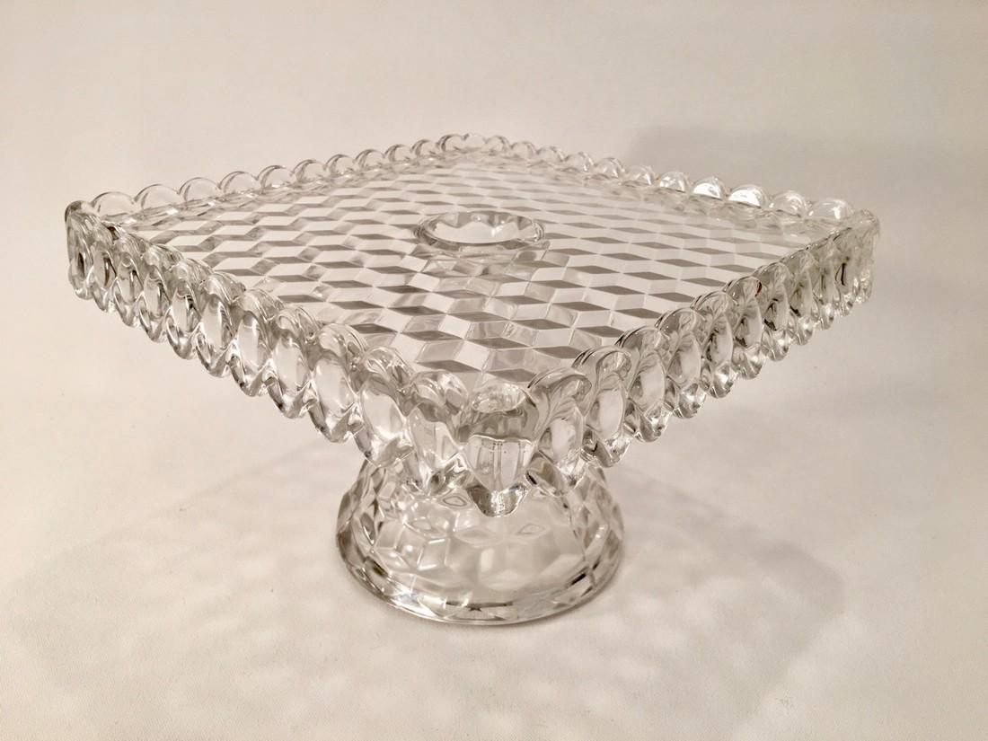 Vintage Fostoria American square pedestal cake stand: Title: Vintage Fostoria American square pedestal cake stand with rum well Date/Period: Mid 20th C Materials: Glass Dimensions: 10 1/4" square x 7" h Description:Vintage Fostoria American square cake s