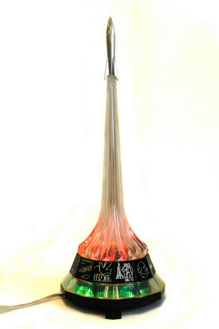 Russian racket lamp: Title: Russian racket lamp Date/Period: 1980 Materials: plastic Dimensions: 15 x 37 x 15 cm Russian lamp shaped starter rockets with Soviet, propagandistic scenes at the base. Reserve: $90.00 Shipping