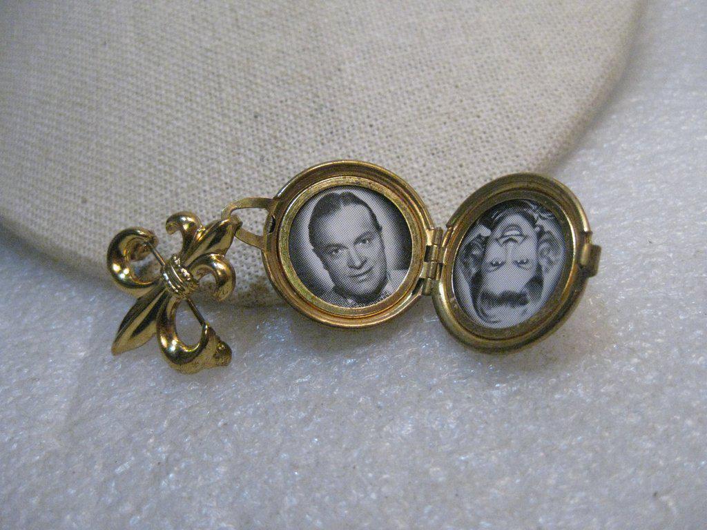 Vintage Fleur-de-Lis Locket Brooch, celebrity photos -: Vintage Fleur-de-Lis Locket Brooch, celebrity photos - Bob Hope, Doris Day. 2.25" long and about 7/8" across. It is a thick gold tone locket with a hinged bottom and stamped face and back. It is in ve