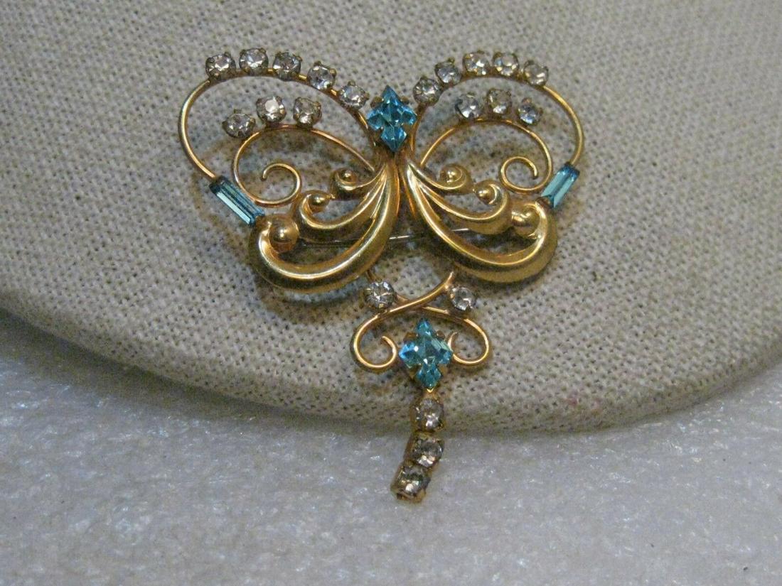 Vintage 1940's Scrolled Rhinestone Brooch and pendant: Vintage 1940's Scrolled Rhinestone Brooch and pendant combination- 1/20 12kt gold filled, signed DeCurtis. It is 1.75" wide and 2" long with a dangling rhinestone chain, three links. It has both the p