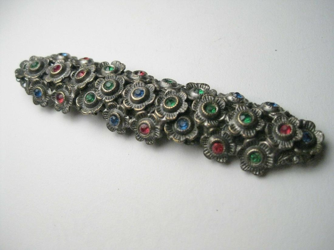Vintage, in a baroque style long brooch that is domed -: Vintage, in a baroque style long brooch that is domed - 3.5" long and 3/4" wide - floral blossoms in a row with a glass or crystal type stone as it's center in red, green, or blue - the underneath is 