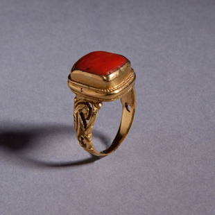 Gold and Coral Ring: Gold and Coral Ring; A Gold ring set with a square coral. The shank of the ring has a foliate design. Reserve: $4,200.00 Shipping:Domestic: Flat-rate of $35.00 to anywhere within the contiguous