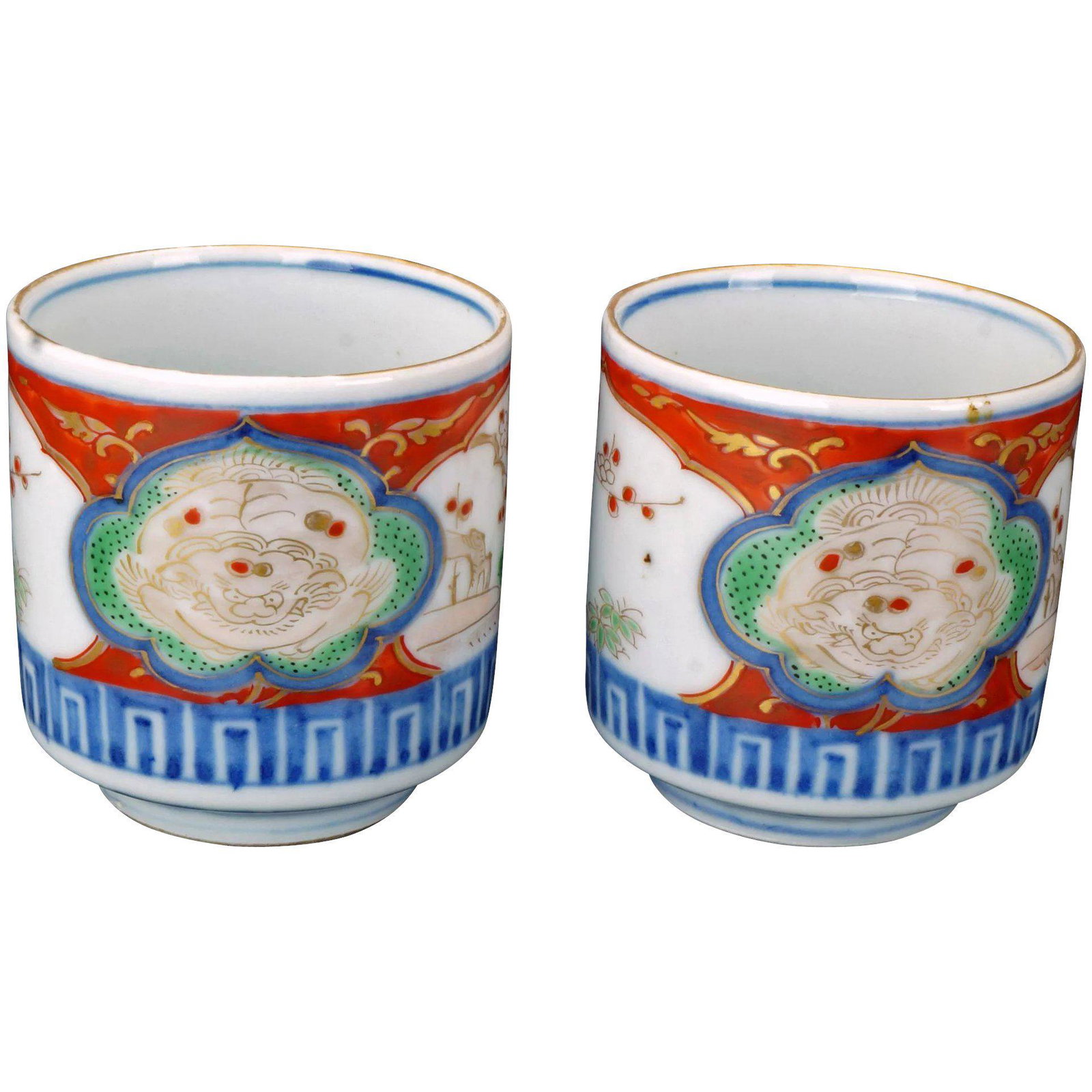 Pair Meiji Japanese Imari Shi Shi Teacups: Small porcelain Japanese Imari teacups with minute, intricate, colorful paintings of a shi shi and landscapes. Small cylindrically-shaped cups of thinly potted porcelain with alternating panels of lan
