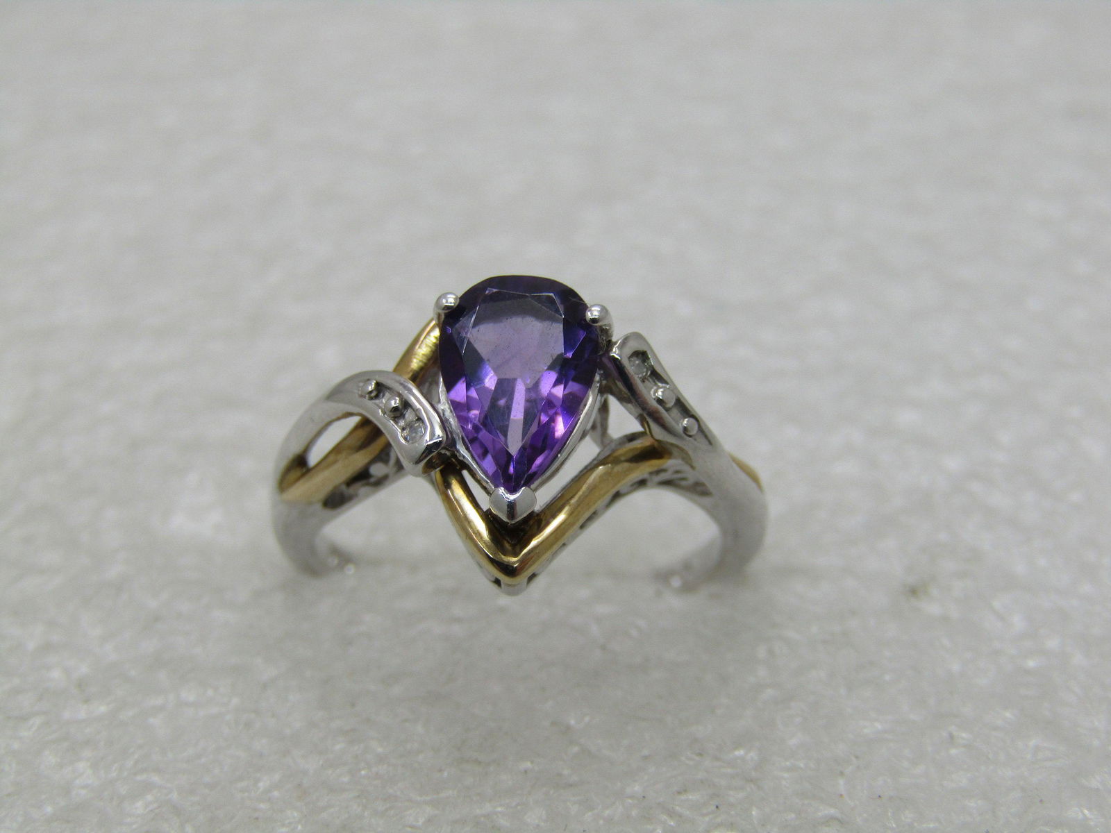 Sterling and 10kt Lab Amethyst & Diamond Ring, Sz. 675.: Sterling and 10kt Lab Amethyst & Diamond Ring, Sz. 675. Pear-Shaped Stone appx. 1.15 TCW with two 1mm diamond chips. Weight is appx. 3.17 gr. This is marked .925 and 10kt. This has 10kt yellow gold fr
