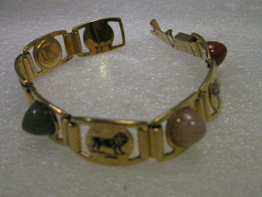 Vintage Gold Tone African Animal Linked Bracelet with: Vintage jewelry: vintage gold tone African animal linked bracelet with 4 hardstone accents. 7.25" long. There is a stamped giraffe, lion, elephant, and elk-like animal with twisted antlers - they are 