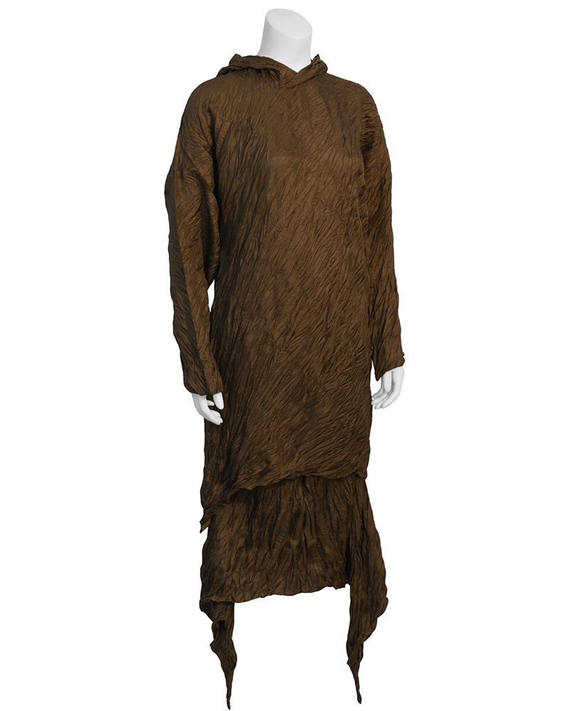 Issey Miyake Brown Crinkled Set: Amazing Issey Miyake brown signature crinkled polyester top and skirt duo from the 1980's. Crinkled long sleeve pullover is tunic length with a pointed hood. Mid length skirt has elasticized waist and