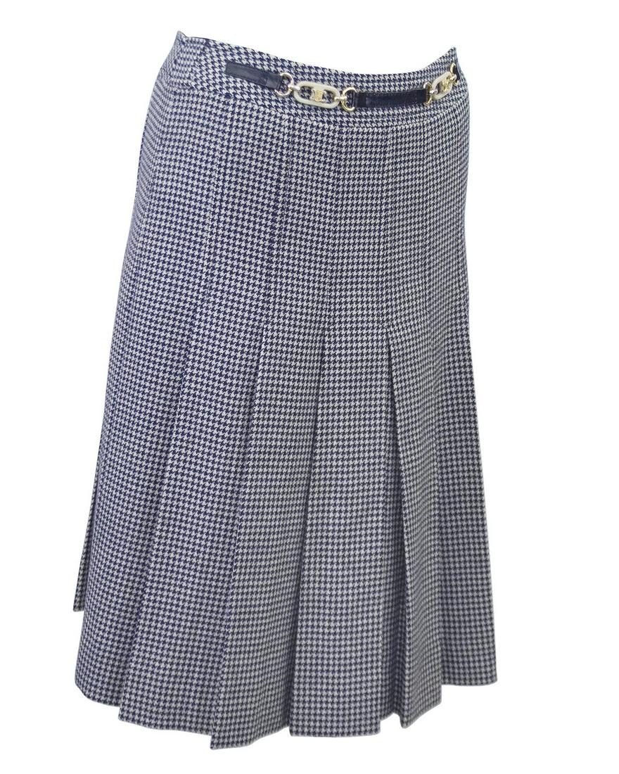 Celine Navy Houndstooth Skirt: 1970s Celine navy houndstooth wool skirt with attached belt detail. The skirt is fitted through the kips and has a pleated bottom that hits below the knee. Zipper up the back with a top hook. The fron