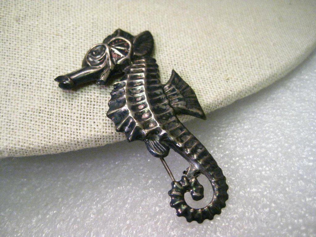 True Vintage Sterling Silver Seahorse Brooch, 2.5" and: Vintage Sterling Silver Seahorse Brooch, mid-century, very detailed. Slightly over 2.5" tall and 1" wide. Weight is 6.68 grams. It is signed sterling on the back behind the nose. I did not see any oth