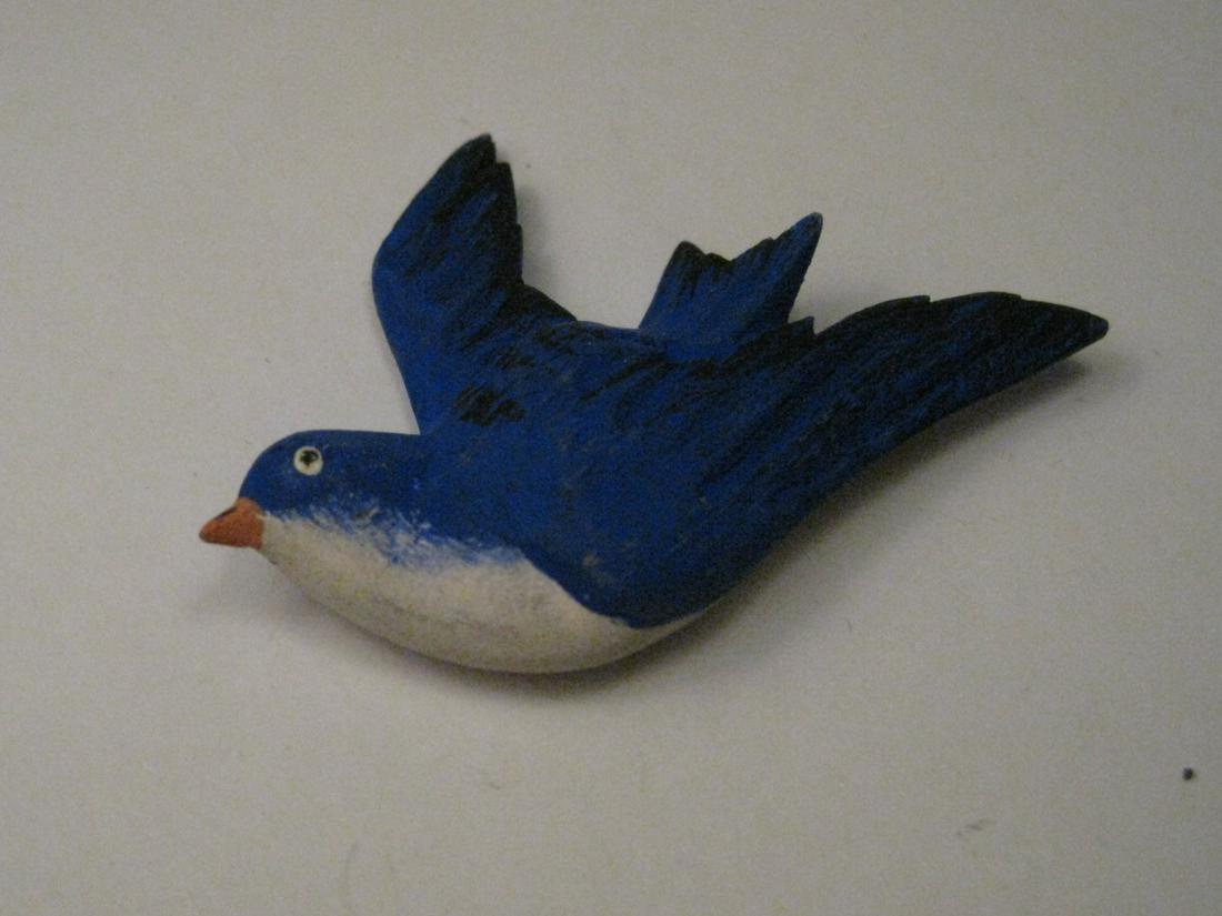 Vintage Hand Painted Blue Bird Wooden Brooch: Vintage hand painted blue bird brooch. Wooden, blue and white with black wing tips. It is 2" wide and 1.5" tall. Hand painted. The back is mostly unpaided. The bird is 3D and not just a flat piece of