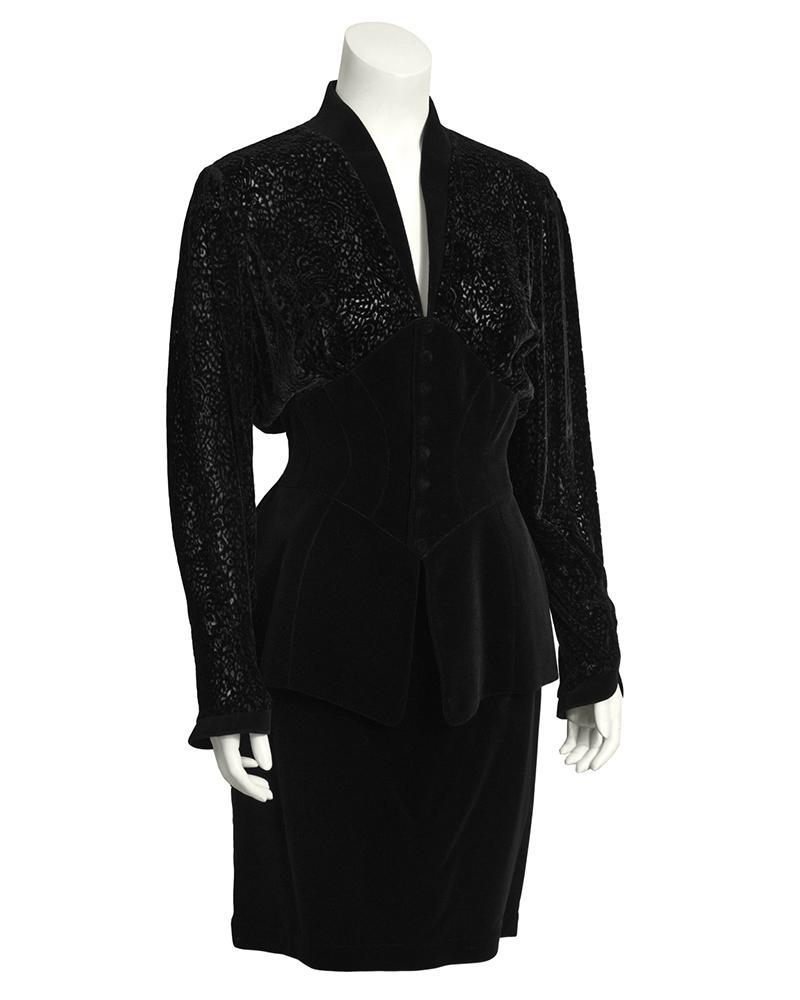 Thierry Mugler Black Velvet Skirt Suit: This fabulous and unique Thierry Mugler black velvet skirt suit dates from the 1980's. Jacket features a loose fitting flocked velvet bodice, with a cinched corset waist, and a front snap button closu