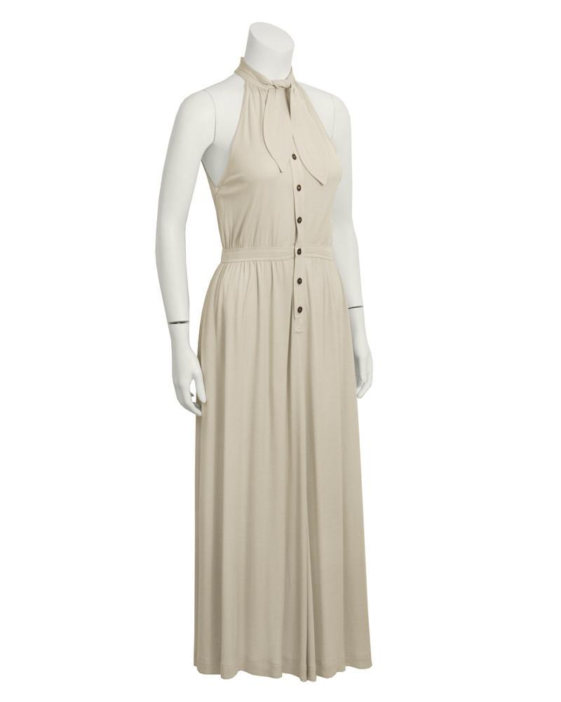 Jean Muir Beige Sleeveless Dress with Necktie: This neutral and sexy 1970's British designer Jean Muir's beige sleeveless maxi day dress with neck tie is a timeless testimony to her vision of elegance and simplicity. High neck, halter top, with a 