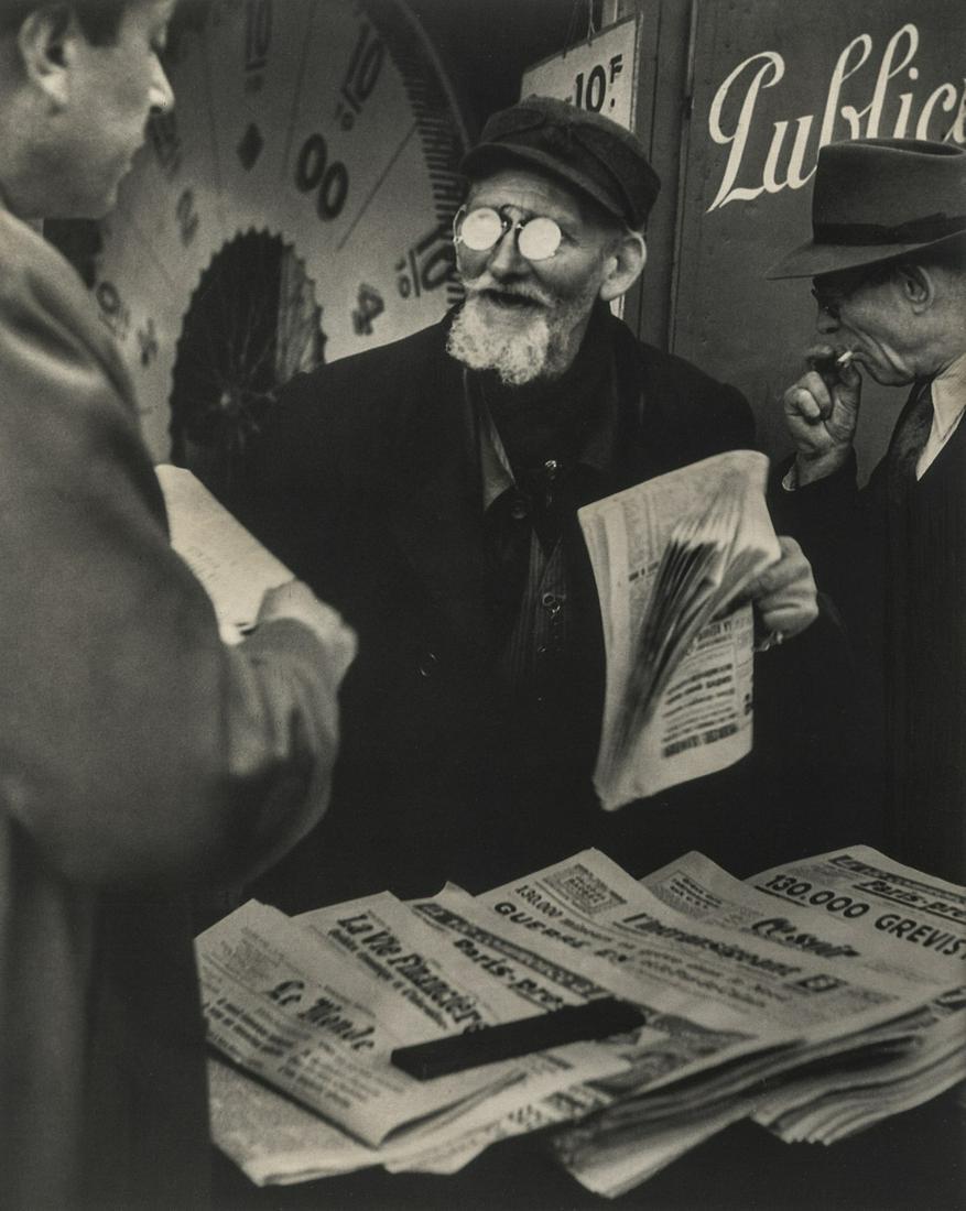 Brassai, Newspaper Seller, Paris, 1948: Artist: Brassai Title: Newspaper Seller, Paris, 1948 Medium: Photo Litho, 1993, Spain Dimensions: 7x8.8" Additional Information: Heat Wax Mounted on 11x14" Conservation Board Artist Bio: Brassai was a