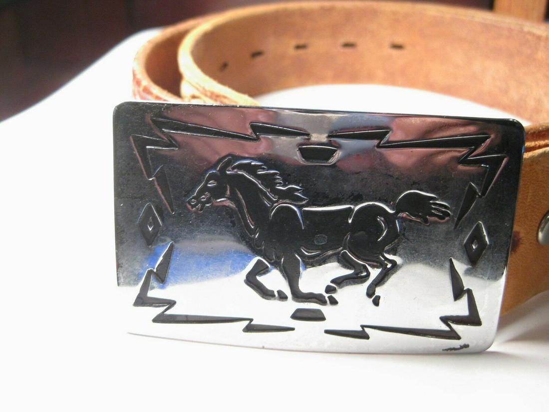 Vintage Southwestern Enameled Horse Belt Buckle &: Vintage Mustang horse with black enameling and Southwest style border designed belt buckle that is attached to a tooled leather belt with embossed pattern of Native American Indian symbols such as the