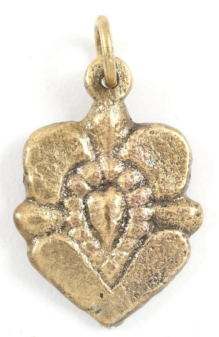 RARE VARIANT VIKING HEART PENDANT, 10TH-11TH C. AD: Gilt bronze, just under 1” height including the loop. Central heart in its naturalistic (uncusped) form as found in the body, with pellet surround. The outside fashioned as flower petals. Made by th