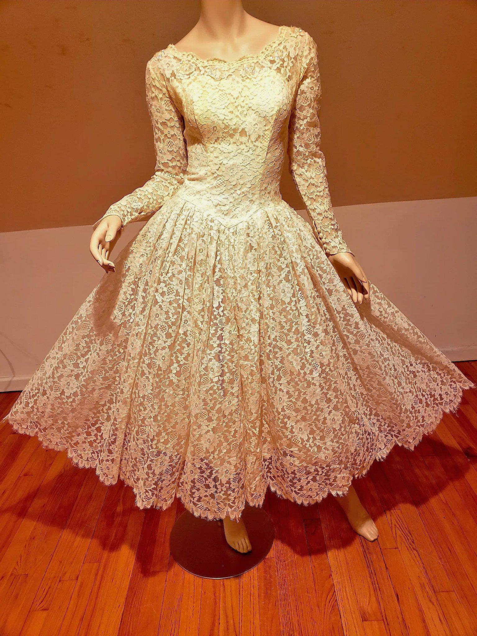 Romantic 1950's Ballerina Length French Lace bridal: Retro Romantic made of beautiful floral patterned French lace, overtop a lightweight cream colored lining, sheer sleeves and buttoned pointed cuffs, Fitted bodice with scalloped neckline dotted with s