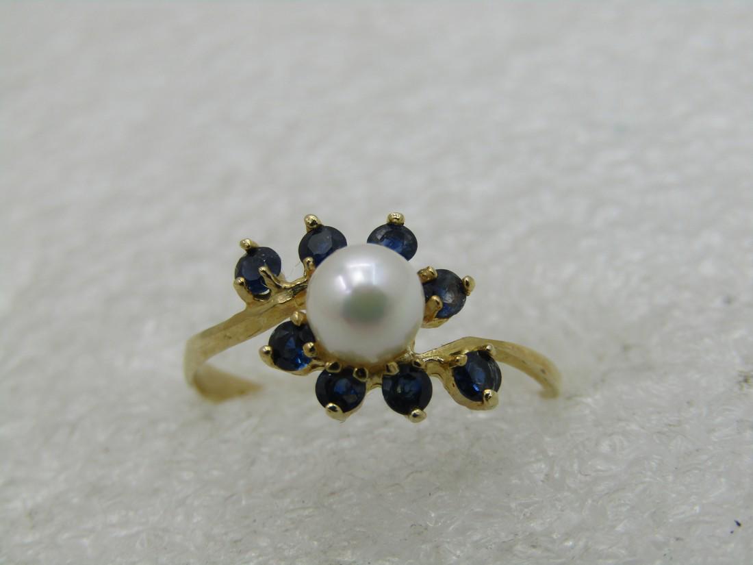 14kt Pearl & Blue Spinel Ring, Sz. 7.5, Blossom Vine: 14kt Pearl & Blue Spinel Ring, Sz. 7.5, Offset Blossom Design. A center 5mm cultured white pearl with an offset or bypass blossom on each side of four 2mm blue spinel stones. The band is appx. .7mm at