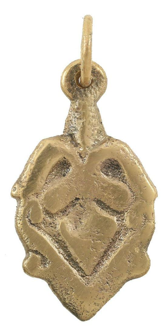 FINE VIKING HEART PENDANT C.900-1050 AD: About 7/8” height plus the suspension loop. The heart in its fully evolved form with cusped top, bordered in a scrolling band. The field, a trefoil sprouting from the borders at the cusp. The foliat