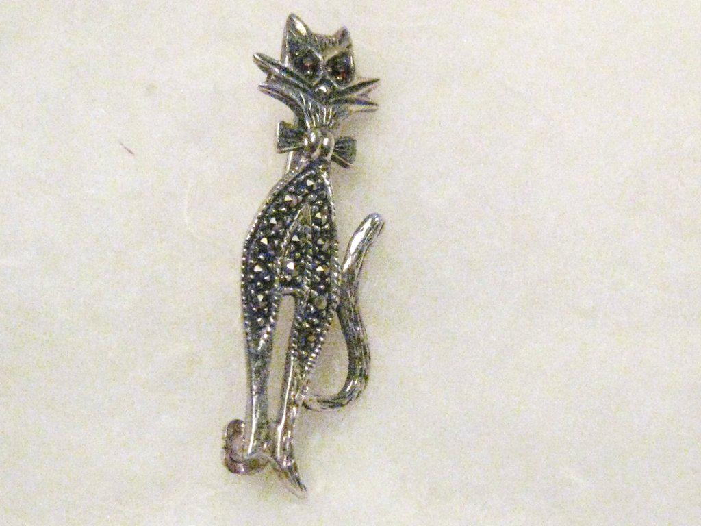 Vintage Sterling Marcasite Cat Brooch, Siamese, 1.5",: Vintage Sterling Silver Marcasite Cat Brooch, with bow tie and red rhinestone eyes. It is 1.5" tall and 5/8" wide, marcasite accents in the torso of the kitty. Weight is appx. 2.95 grams. Age is 1980'