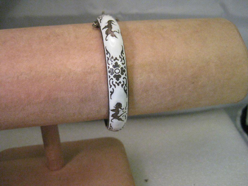 Vintage Siam White Enamel Sterling Silver Hinged Bangle: Vintage Sterling Silver, Siam Hinged White Enameled Bangle Bracelet - 7.25" inside measurement and 8mm wide. The surface is lightly rounded and not flat. Weight is 18.49 grams. It has a safety chain t
