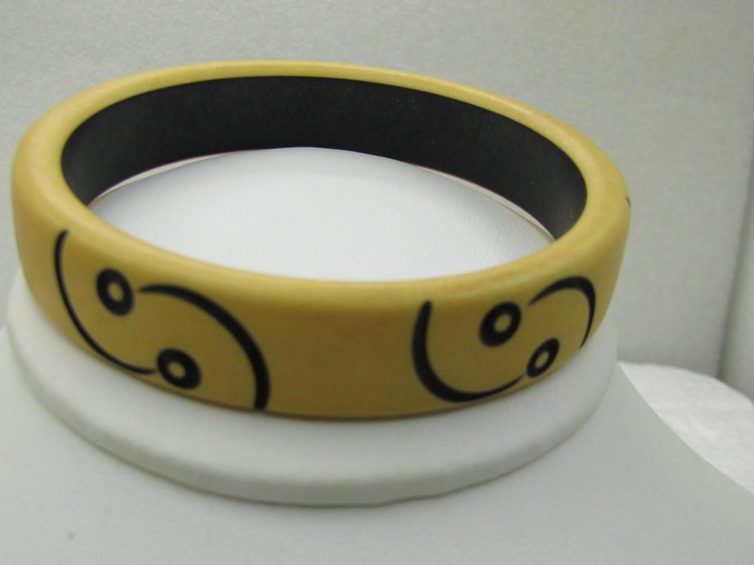 Title: Vintage Bakelite Carved Bracelet, Tan & Black,: Vintage Bakelite Carved Bracelet, Tan & Black, Enameled, 8" and an opening of appx. 2-5.8". 14.5mm wide with a black painted inside to the bangle and carved curved enameled black lines and circles. 19
