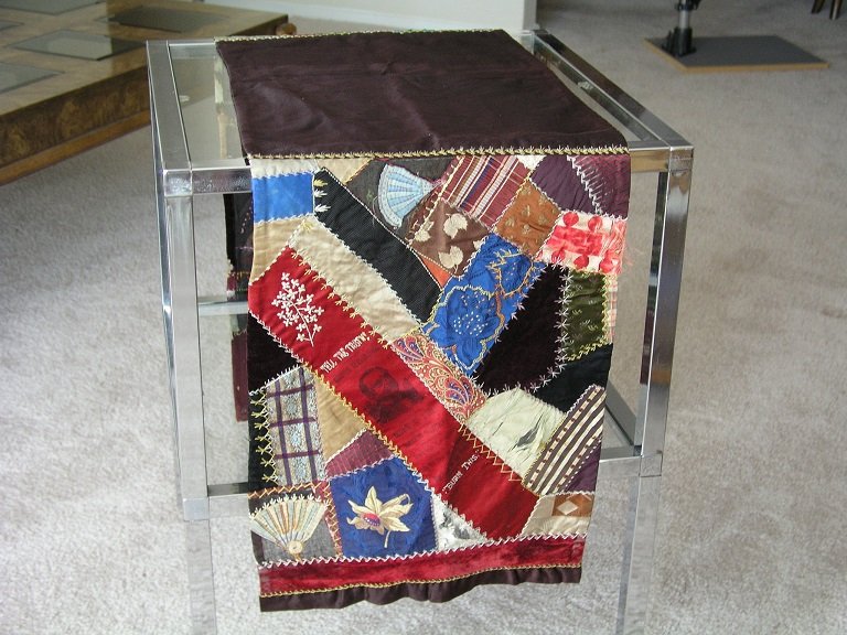 Table Cover with Outstanding 1884 Campaign Ribbon: Grover Cleveland: Table Cover with Outstanding 1884 Campaign Ribbon. 14 1/2” x 61” silk, satin and felt table cover. The sides which hang over the side of the table have patchwork designs. What el