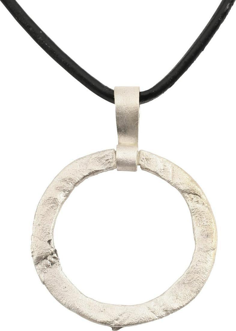 VIKING PROTECTIVE BROOCH NECKLACE, 10TH-11th CENTURY: Circular bronze, just over 1 1/8” diameter of flattened form. Flat back and cross pin slot to the edge. The front with low relief scrolling floral decoration in the Viking taste. The surface with li