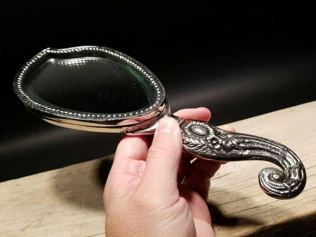 Metal Hand Mirror: 11' Long x 4 1/4" wide Such a great reproduction hand mirror! All metal aged silver color with a cherub on the back side. Nice heavy quality for use or display! Reserve: $20.00 Shipping: Domestic: Fla