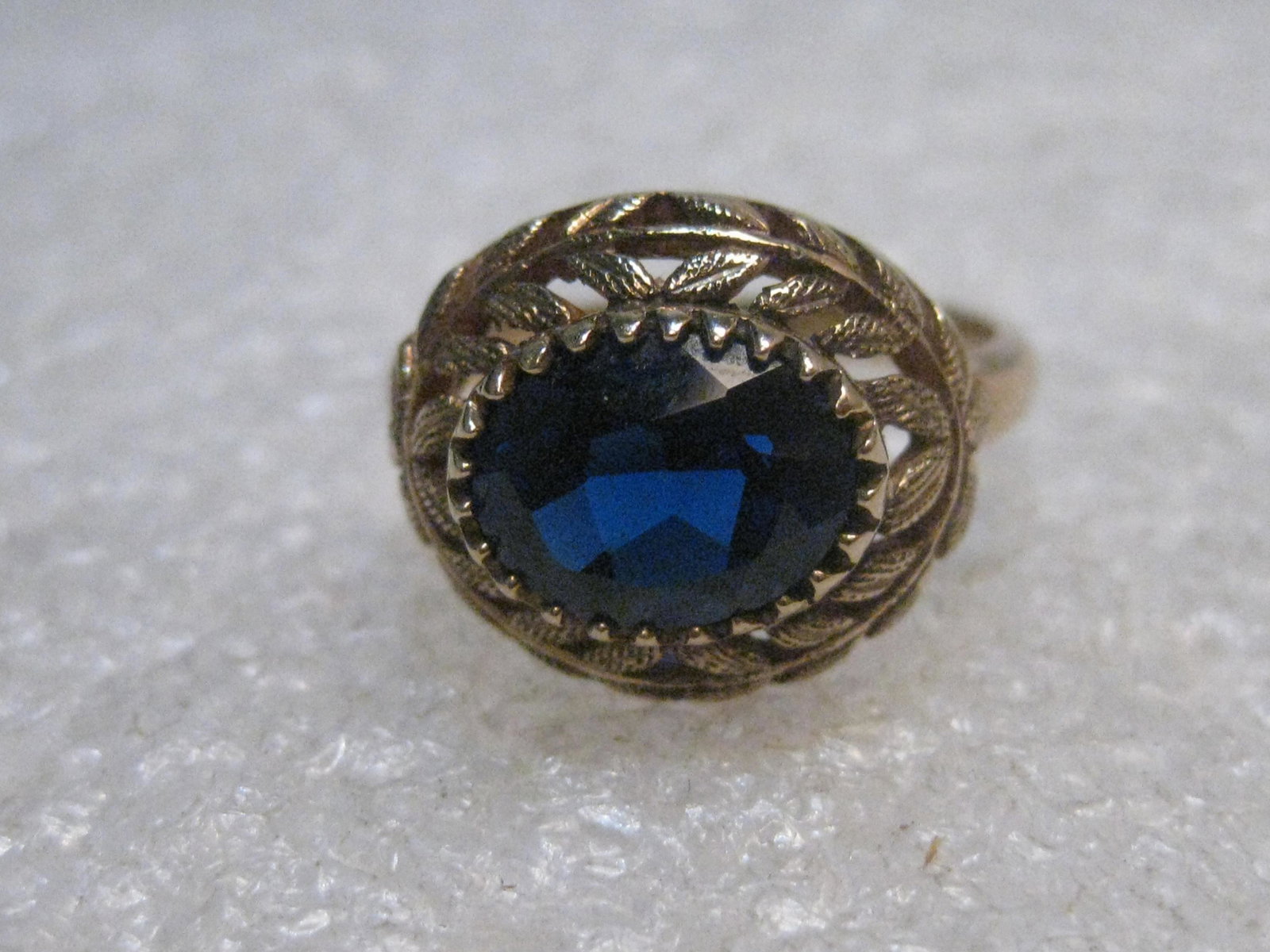 Vintage 10kt Blue Spinel Ring, size 5.5, Mid-Century,: Vintage 10kt Blue Spinel Ring. Size 5.5. This is a blue spinel, long side sideways on the finger with an ornate bezel setting. It sits on top of a domed leaf-like frame that is appx. 6mm high. The ban