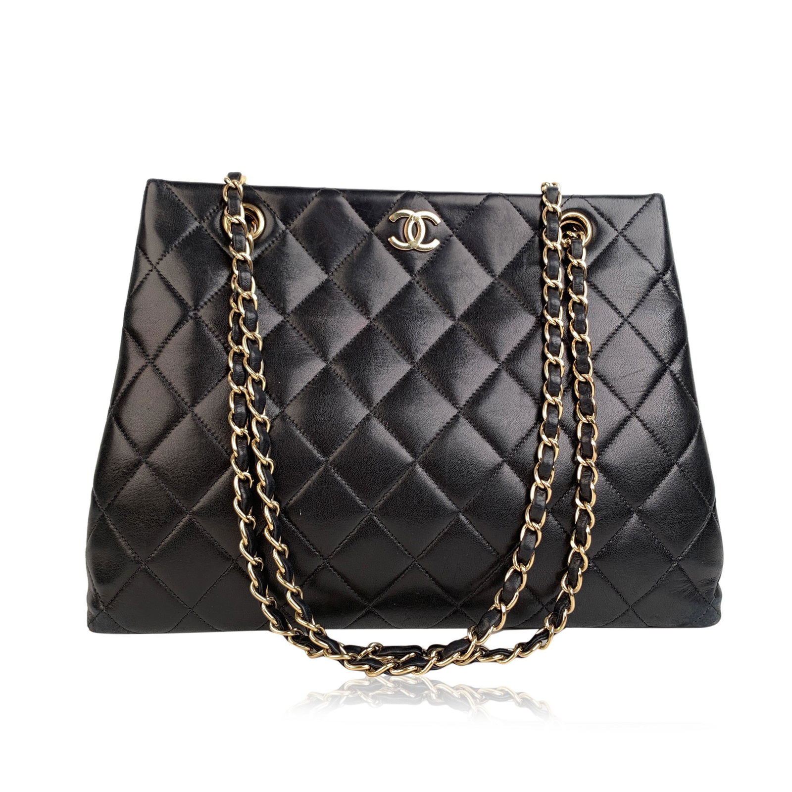 Chanel Vintage Black Quilted Leather Tote Shoulder Bag: Sophisticated black quilted leather shoulder bag by CHANEL with double gold metal chain and interwoven leather shoulder straps. Gold metal CC - CHANEL logo on the front. The bag features upper magneti