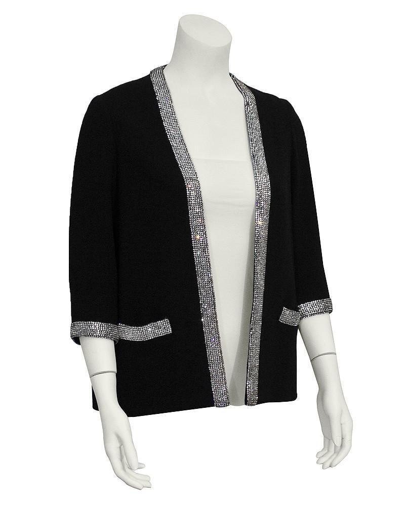 Norman Norell Black Wool Jacket with Rhinestone Trim: Fabulous 1960's black wool jacket trimmed in silver rhinestones. Open front with flat front pockets and bracelet length sleeves. In excellent vintage condition, minor restoration has been done to the 