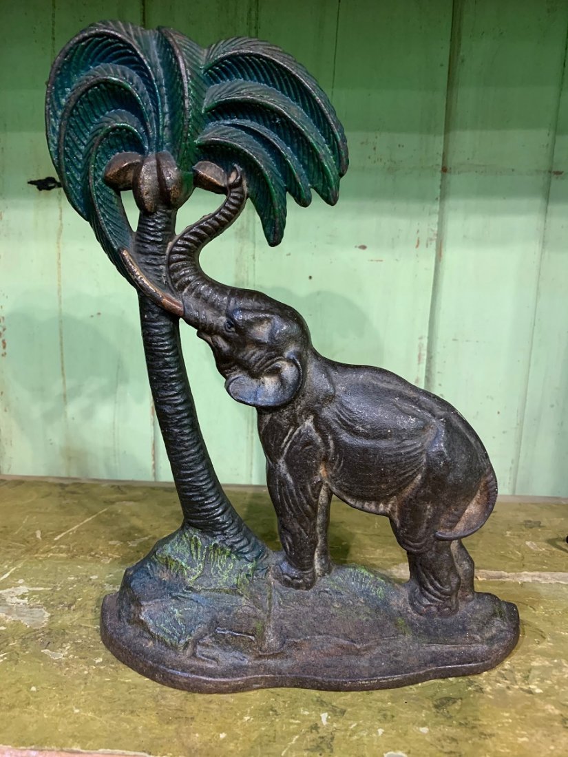 Antique Cast Iron Door Stop Elephant By Coconut Tree: Title: Antique Cast Iron Door Stop Elephant By Coconut Tree Date/Period: Approx 1930-1940 Materials: Cast iron Dimension: Approx: 13 3/4 x 10 /14" Shipping: Domestic: Flat-rate of $25.00 to anywhere w