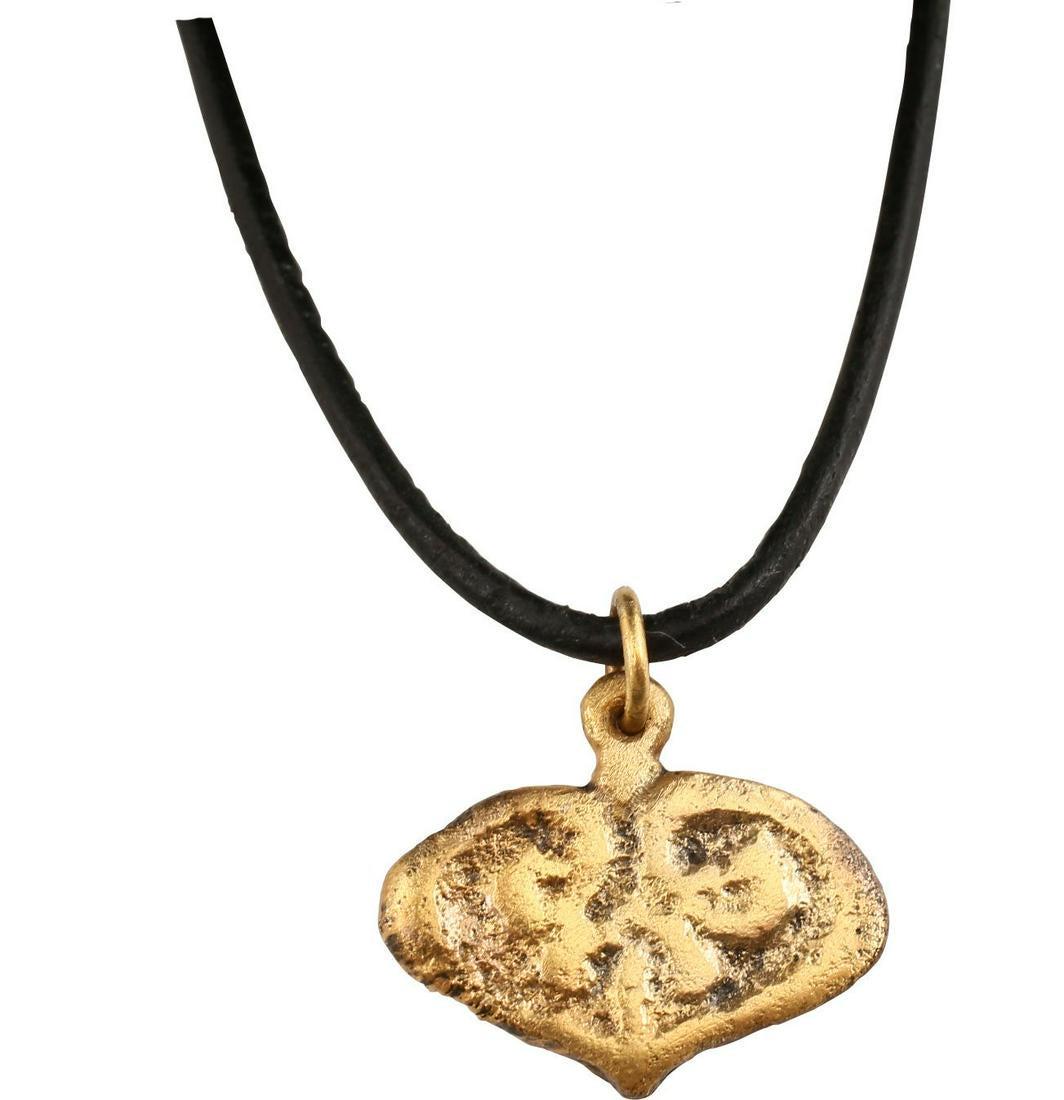 ICONIC VIKING HEART PENDANT NECKLACE 10TH-11TH CENTURY: Fully evolved form with cusped top and broad rounded edges curling to a symmetrical foliate motif within. The foliate theme was a very popular motif for Viking hearts. Just over 7/8Â” width. The he