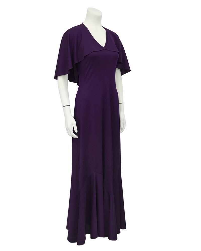 Clovis Ruffin Purple Capelet Dress: Fabulous vintage maxi dress from the 70's. Features a low, v-neck in front with square sleeves that hang in a cape-like style. Long, flowing full length maxi skirt. Made of lightweight knit polyester