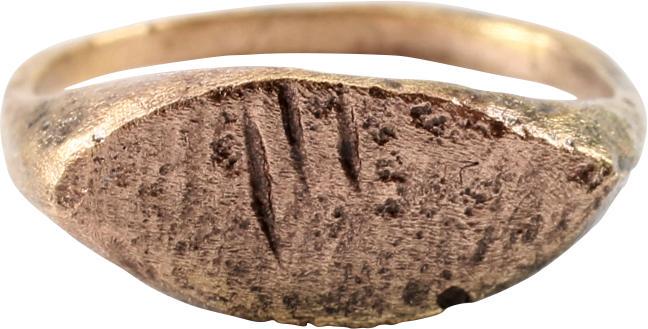 MEDIEVAL WOMAN’S FASHION RING C.1200-1400 AD: Size 4 3/4 for the small finger as was the fashion. Rounded band 1.6mm width flaring to the ridged shoulders. Pointed oval bezel cut with strokes and dots on a textured ground in imitation of a signet