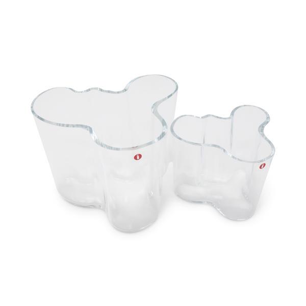 Set of Two Alvar Aalto for Iittala Glass Vases: A pair of small, clear glass vases designed by Alvar Aalto for Iittala. Designed in 1937, the lines of the vase were inspired by the plentiful bodies of water found throughout Aalto's native Finland. 