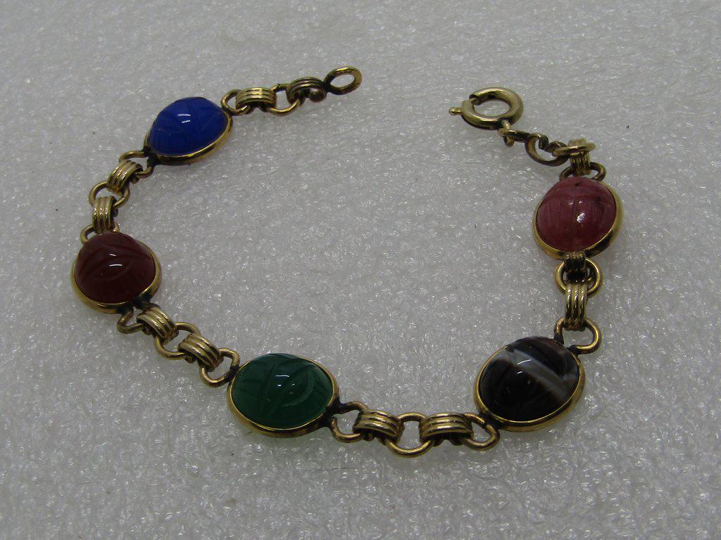 Vintage Scarab Bracelet, 1/20 12kt G.F., 7.5", 1960's: Vintage Scarab Bracelet, 1/20 12kt G.F. 7.5". Five scarabs - Egyptian themed bracelet with a blue, carnelian, jade, brown agate, and pink stone. Ridged connector links connect the links. 1960's. Very 