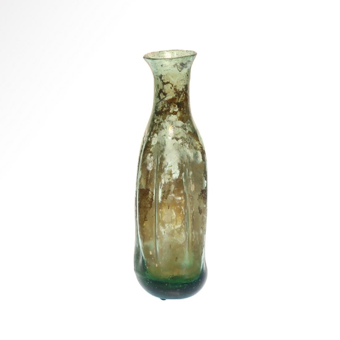 Roman Glass Unguentarium, 2nd Century A.D.: Title: Roman Glass Unguentarium, 2nd Century A.D. Date/Period: Roman, 2nd Century A.D. Material: Glass Dimension: 8.4 cm H - 3 3/8 inches Description: With indented ribbed elongated body, cylindrical