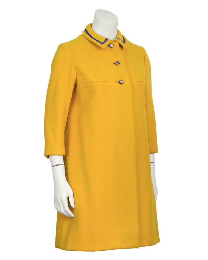 Anonymous Marigold Coat: Anonymous marigold wool coat from the 1960's. The petite coat features a seamed yoke and unique pewter square buttons on the front. The collar is piped in a purple and gold ribbon detailing. Finished