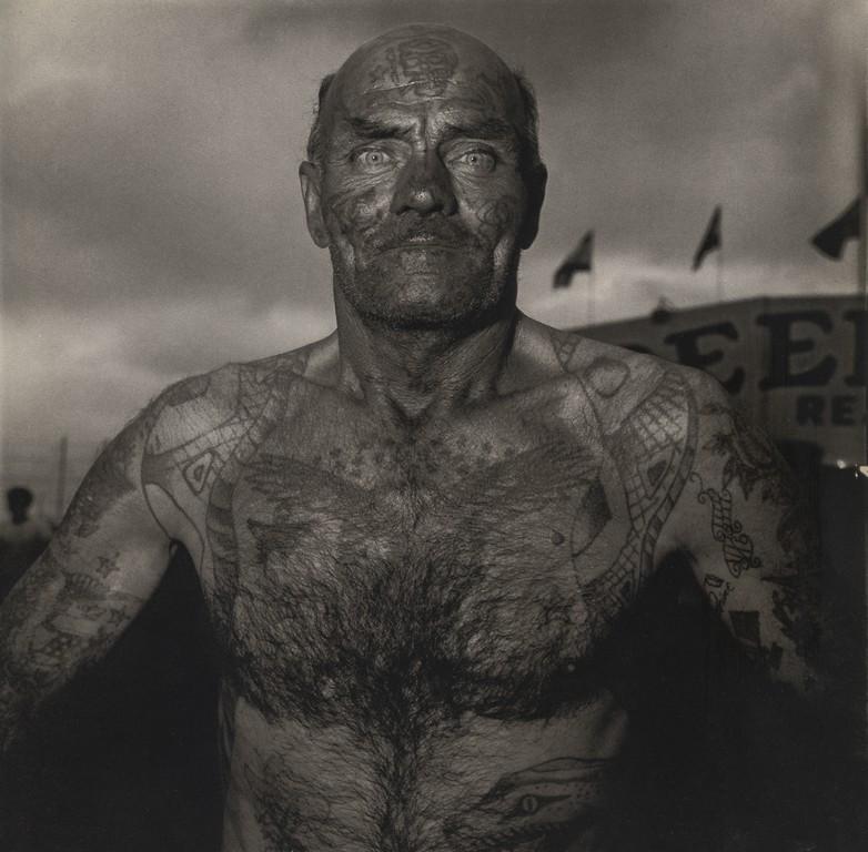DIANE ARBUS - Tattooed Man at a Carnival, Maryland: Artist: DIANE ARBUS Title: Tattooed Man at a Carnival, Maryland, 1970 Medium: Photo Litho, 1972, USA Dimensions: 8.3x8.2" Description: Heat Wax Mounted on 11x14" Conservation Board Artist Bio: Diane A