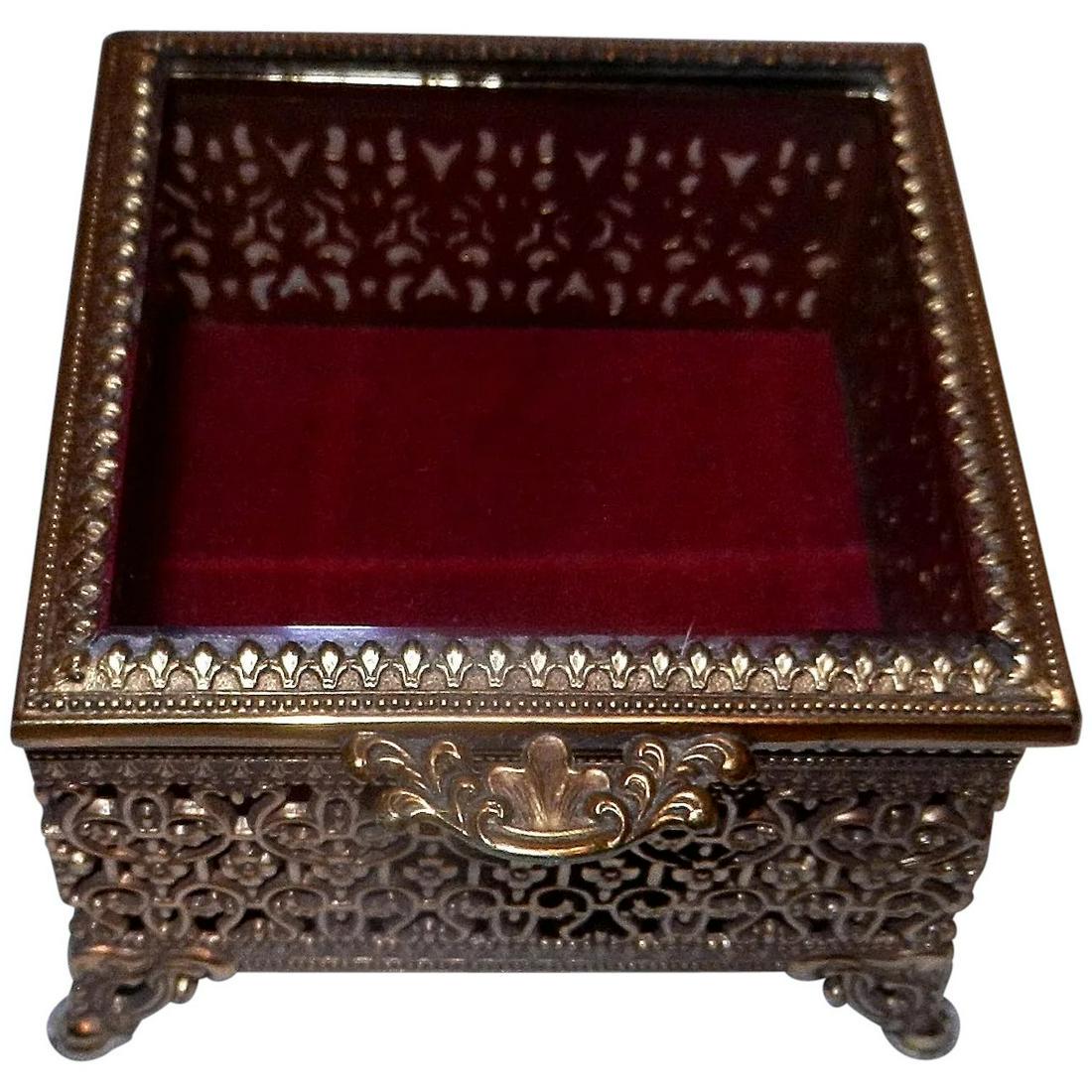 Vintage ORMOLU Footed Gold Plated Square Jewelry Casket: Beautiful ORMOLU gold plated square jewelry casket trinket box. A perfect boudoir accessory; footed dresser box with an ornate filigree, including the fancy dog-tooth pronged beveled glass. Red velvet