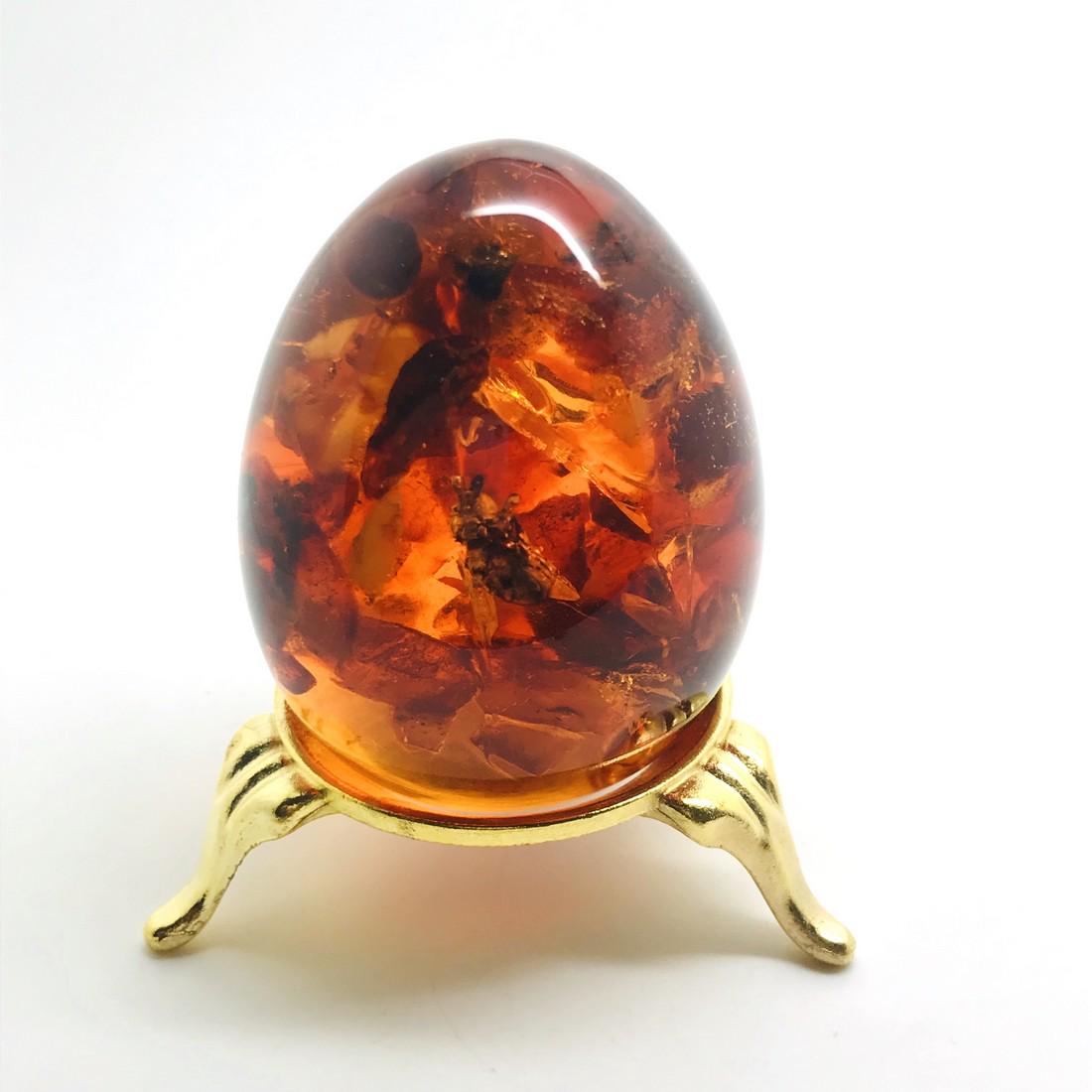 Amber egg with bee insect inclusion, on the stand (1 of 10)