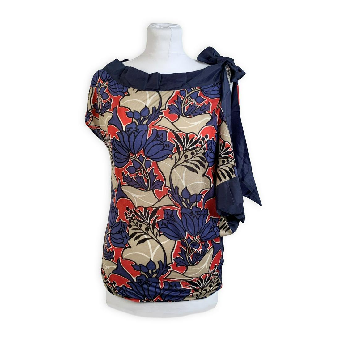 Prada Blue Floral Jersey Asymmetric T Shirt Top with: Prada top t-shirt with floral design in blue red and beige color. It features boat neckline an asymmetric design hadkerchief detailing on the right side and bow detailing on the shoulder. Composition 