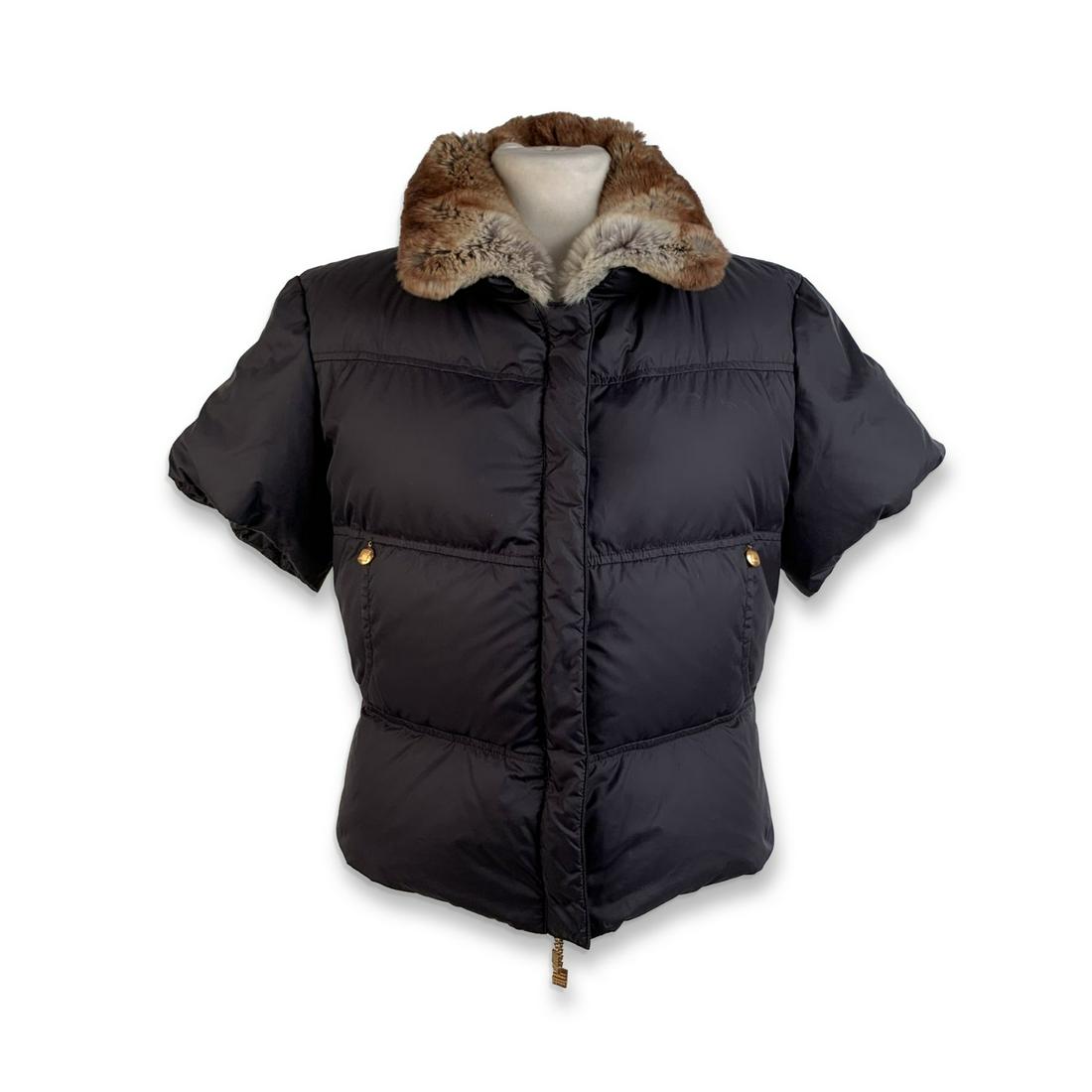 Fendi Black Short Sleeve Down Jacket with Fur Collar: Fendi down jacket with short sleeve styling in black color. Gold metal accents. Fur trim on collar. Button and zip closure on the front. 2 open pockets at the waist. Size: 40 IT. It should correspond