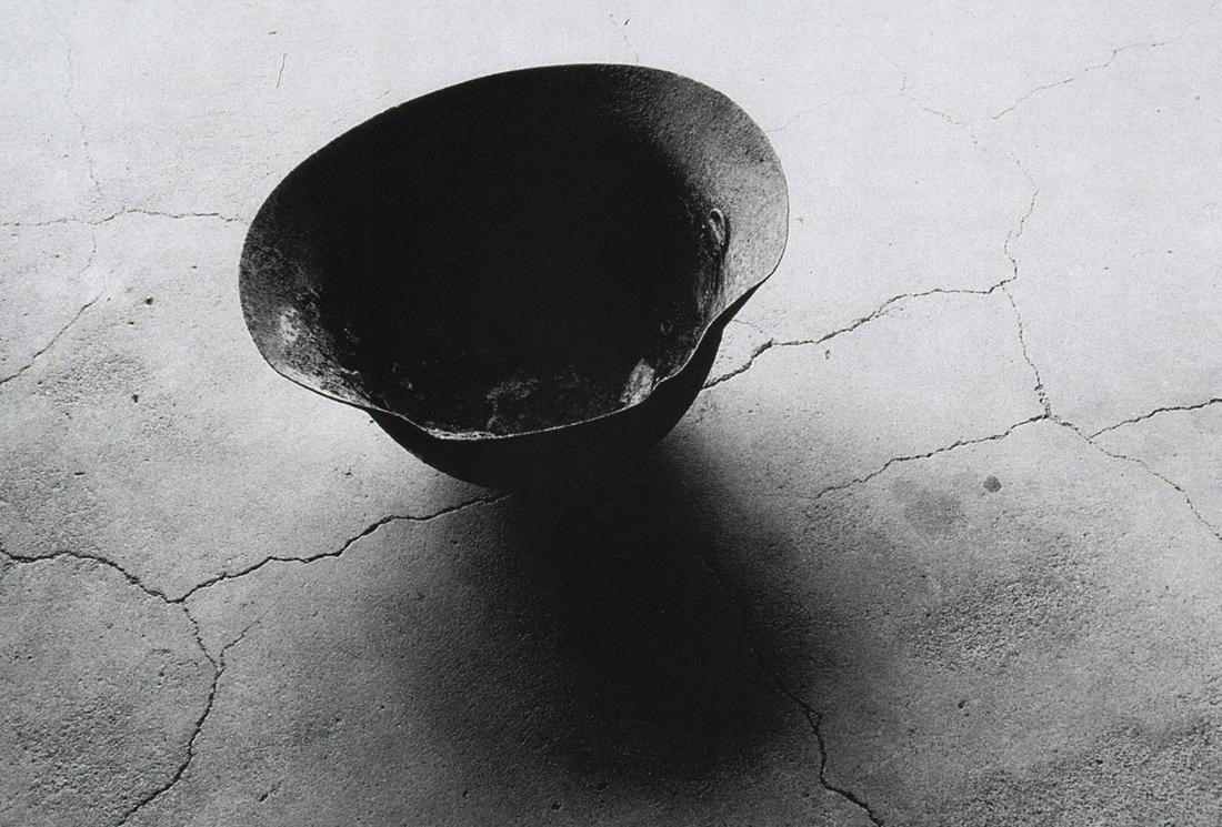 SHOMEI TOMATSU - Steel helmet with skull bone melted: Artist: SHOMEI TOMATSU Print Title: Steel helmet with skull bone melted from an atomic bomb, Nagasaky, 1963 Printing Date: 2000’s Medium: Photolithograph Printed in: Italy Image Size: approx. 7.5 x